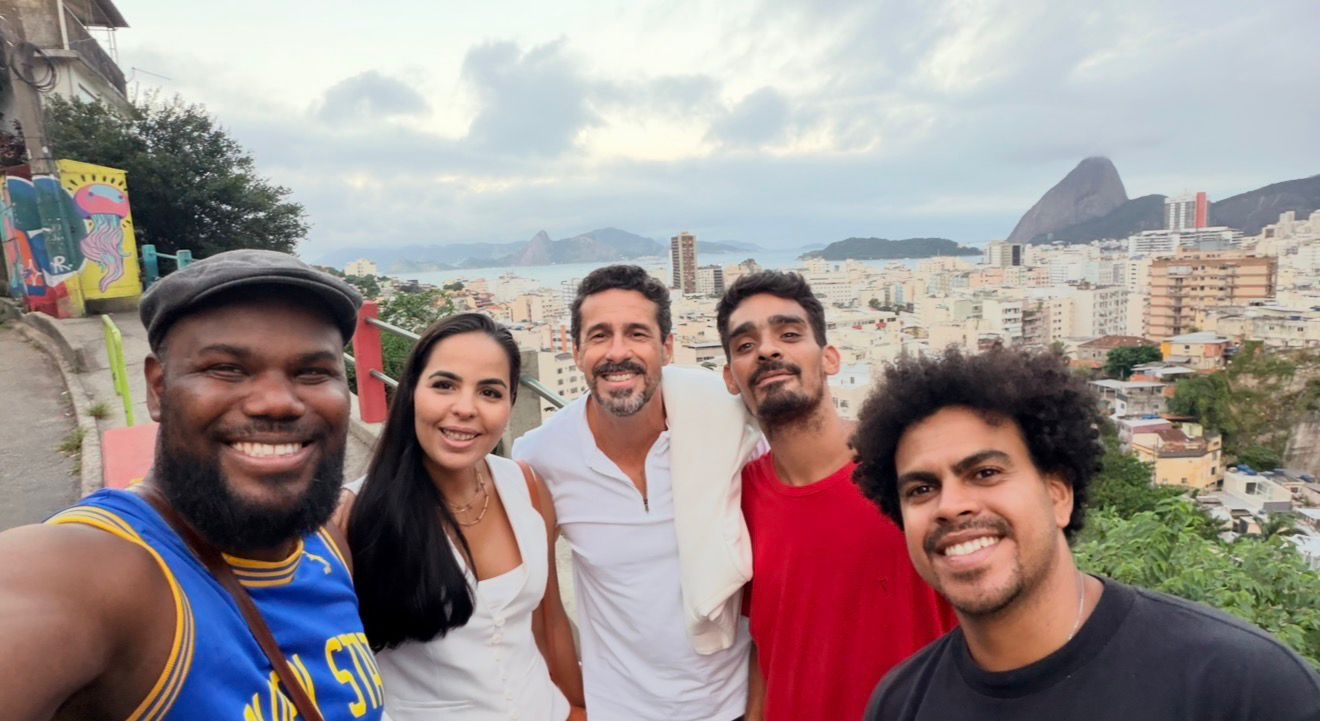 Equipe e moradores reunidos com vista panorâmica do Rio de Janeiro